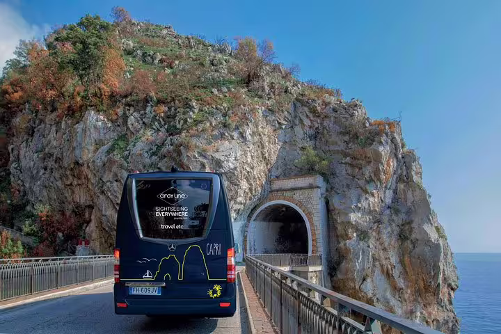 Tour bus on scenic coastal road near Amalfi, offering breathtaking views and easy access to Positano and Ravello.