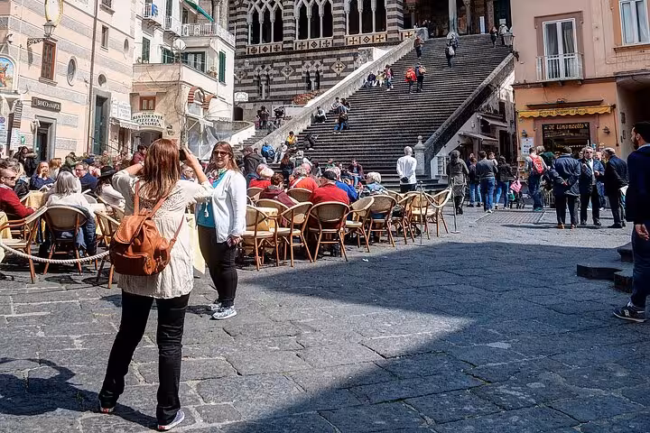 Tourists capture memories at a bustling square near Amalfi Cathedral, highlighting vibrant culture on the Amalfi Coast tour.