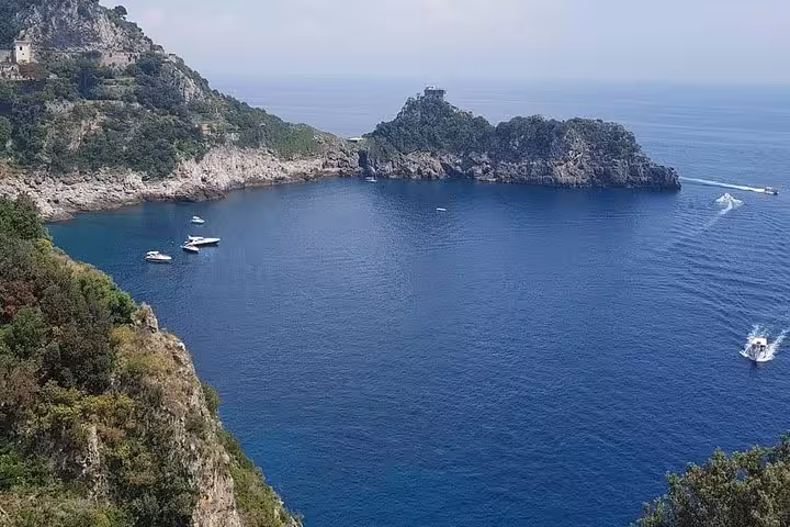 Amalfi Coast bay with turquoise water and boats, scenic stop on Rome to Sorrento and Positano day tour
