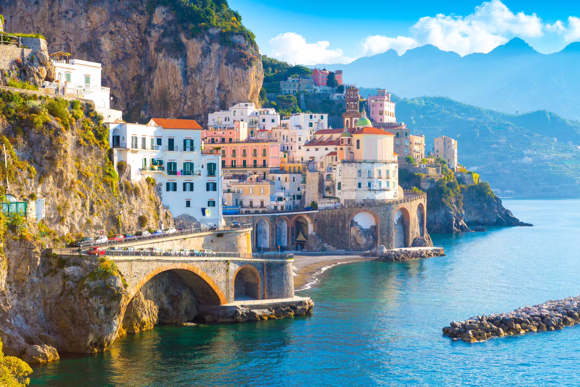 Colorful Amalfi Coast village perched on rocky cliffs above turquoise sea, seen en route on Li Galli and Capri boat tour