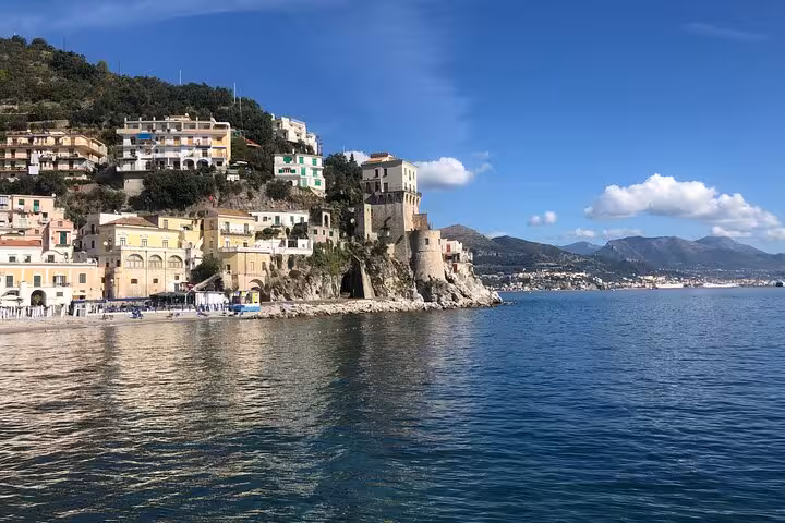 Charming Amalfi Coast village perched on cliffs with colorful buildings and tranquil sea views.