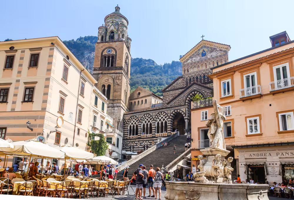 Charming Amalfi town square with the historic cathedral facade and bustling outdoor cafes.