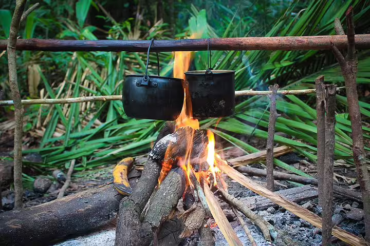 Two pots hanging over a campfire in the Amazon jungle, capturing the essence of outdoor cooking adventures.