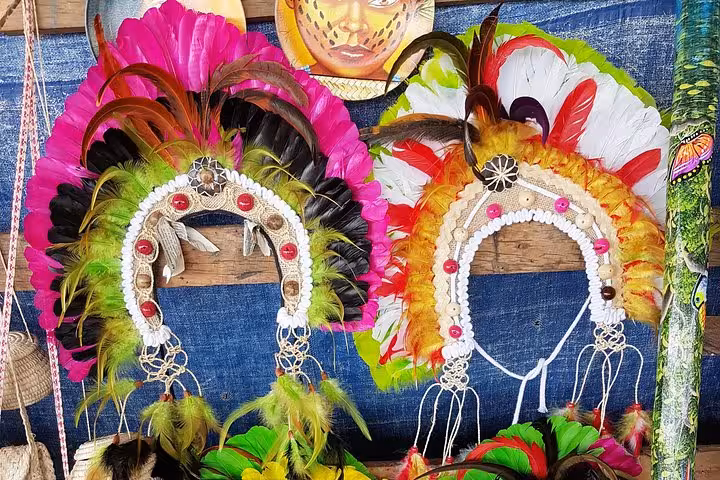 Colorful Amazon indigenous feather headdresses on display at Indian village stop on Manaus river tour