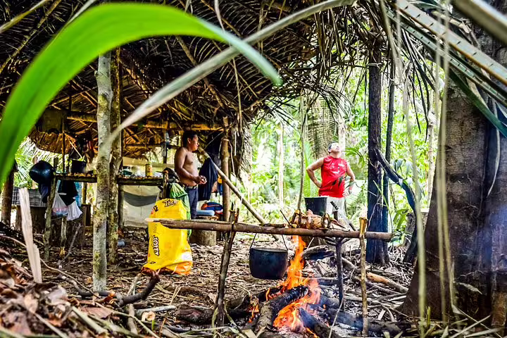 Tourists at a rustic Amazon jungle campfire experience, showcasing authentic Amazon Survival Tour 3D/2N adventure.