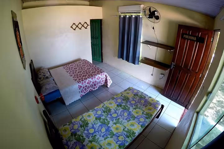 Simple Amazon jungle lodge room with twin beds and AC, comfortable stay on 6-day Amazon Jungle Adventure Tour