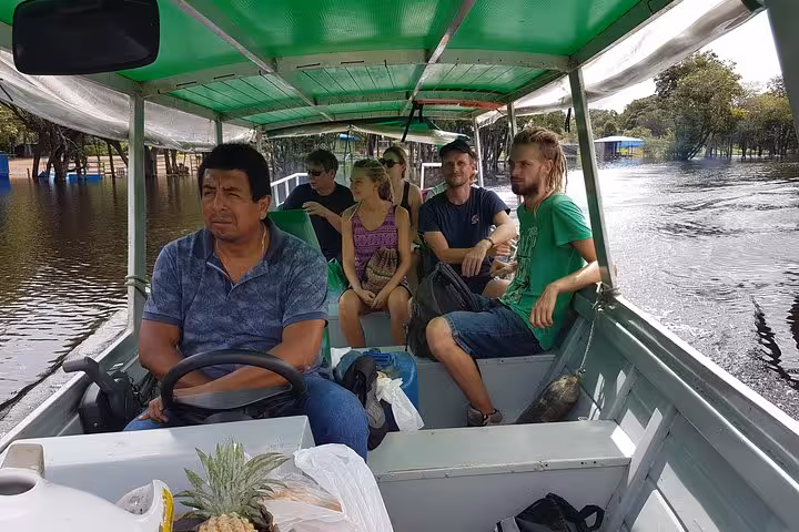 Travelers ride a motorboat on flooded Amazon river, part of a 4-day Amazon jungle adventure tour