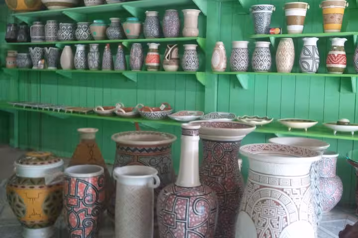 Handcrafted Amazon pottery vases and bowls on green shelves in Santarém do Pará city tour stop
