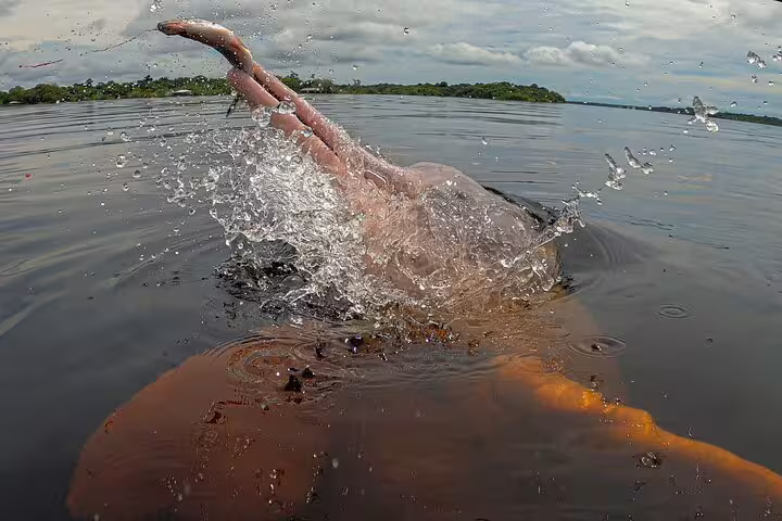 Playful river dolphin splashing in the Amazon, a unique experience at Tapiri Rio Negro Lodge jungle adventure.