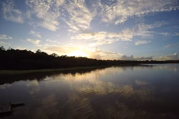 Sunset over the Amazon River on the Manaus to Santarém boat journey, with calm waters reflecting clouds and rainforest