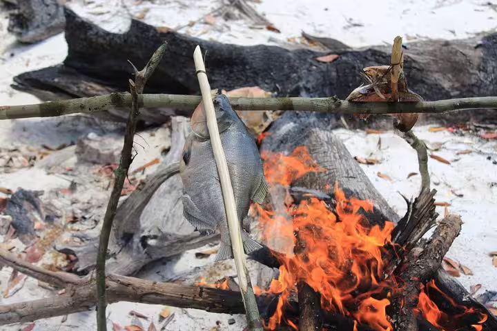 Immerse in wilderness skills by cooking freshly caught fish over a campfire on the Amazon Survival Tour adventure.