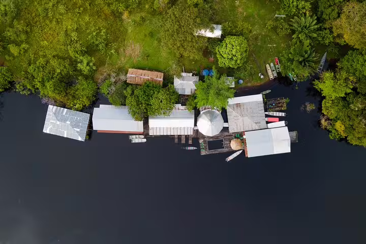 Aerial view of Amazon Tapiri Floating Lodge nestled beside the lush green Amazon rainforest.