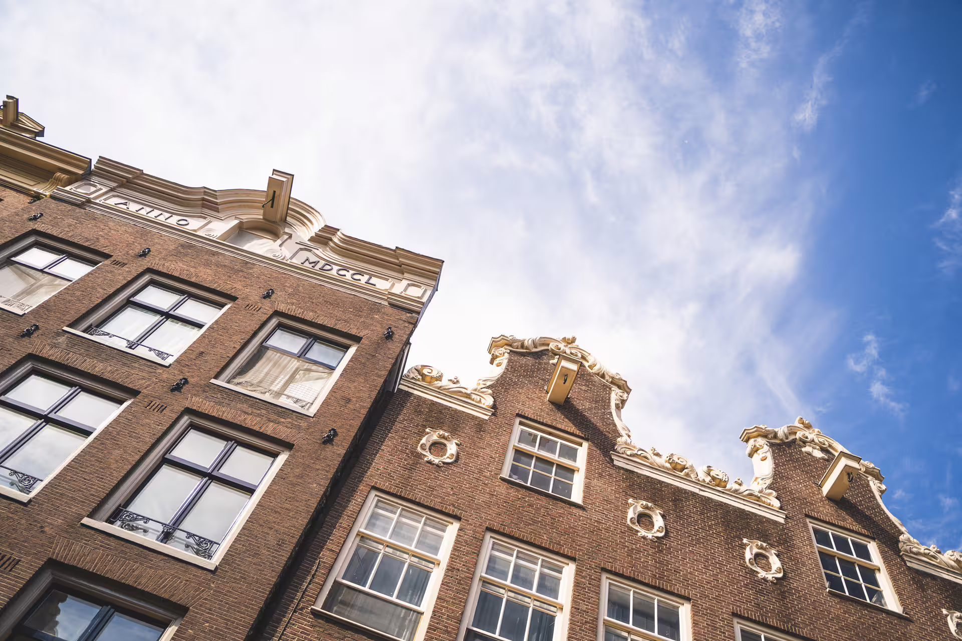Historic Dutch gabled buildings under a clear blue sky in Amersfoort, featured in our walking tour from Amsterdam by train.