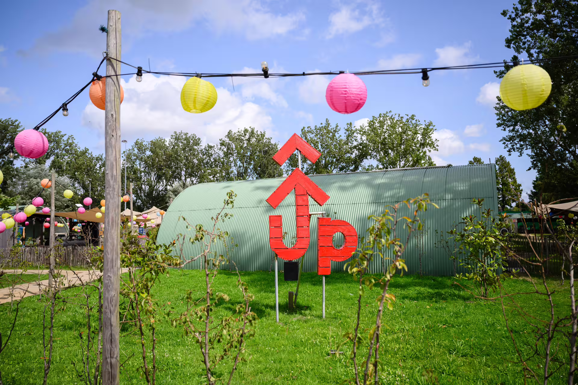 Outdoor Amsterdam axe throwing location with lantern lights and bold sign, ideal for group events and parties