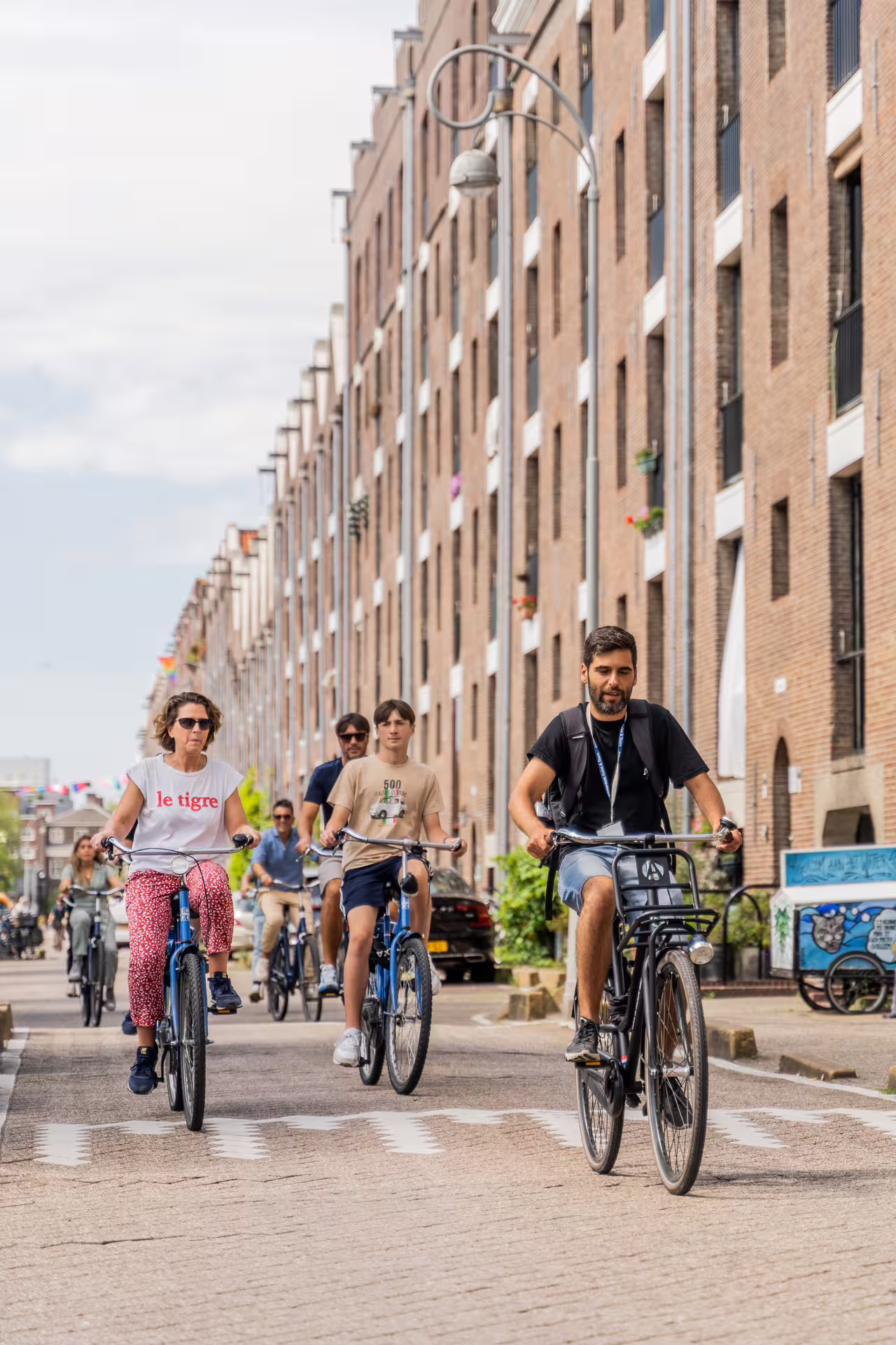 Cyclists enjoy a scenic bike tour through Amsterdam's charming streets, perfect for exploring canals with cheese and drinks included.