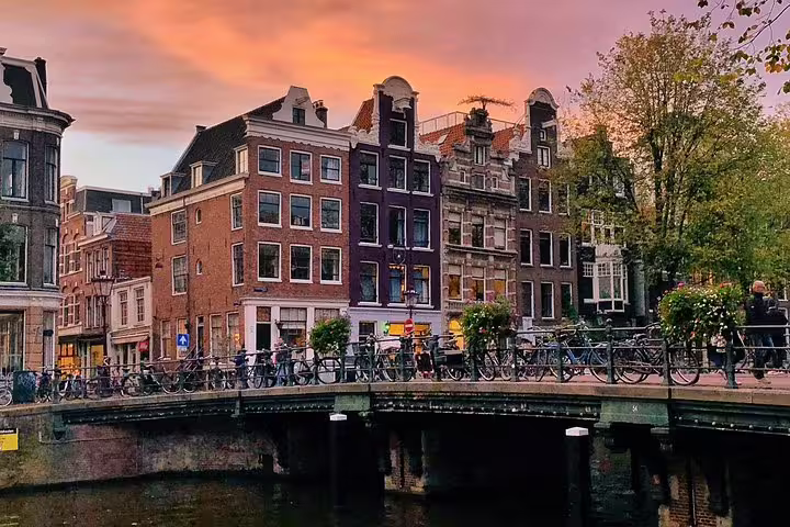 Amsterdam canal bridge at sunset with historic houses, scenic highlight on a private painters walking tour