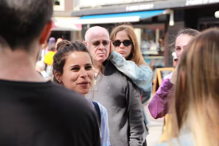 Group enjoying an Amsterdam walking tour, featuring canal cruise, unlimited drinks, and cheese tasting experience.