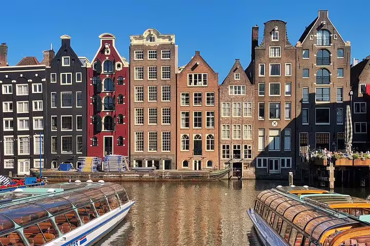 Canal houses and glass-roof boats on Amsterdam canal, perfect for a private walking tour highlights