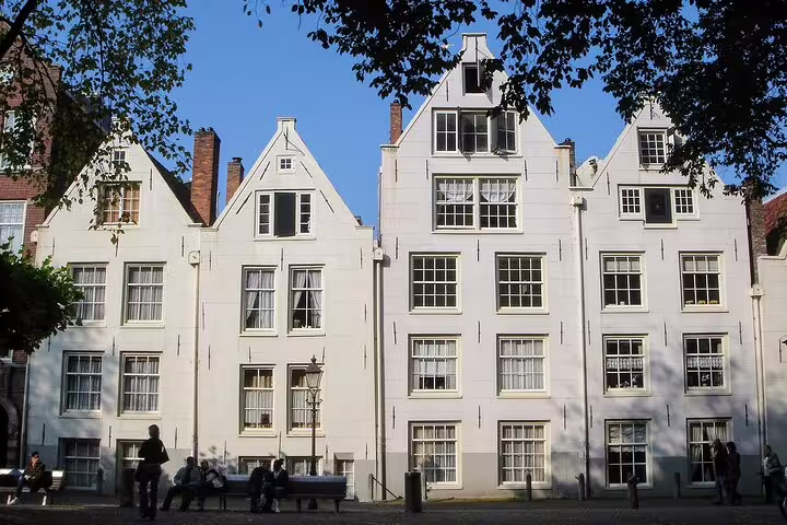 Historic white canal houses in Amsterdam, scenic stop on sightseeing tour featuring hidden gems, tastings and PDF guide