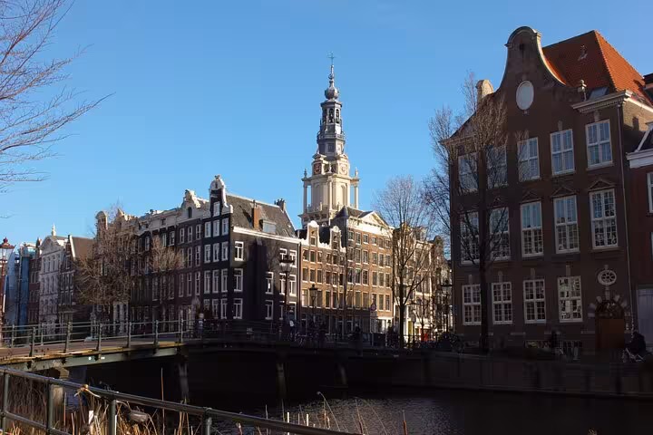 Amsterdam canal houses and Zuiderkerk tower on a sunny day, ideal stop on a customized private walking tour