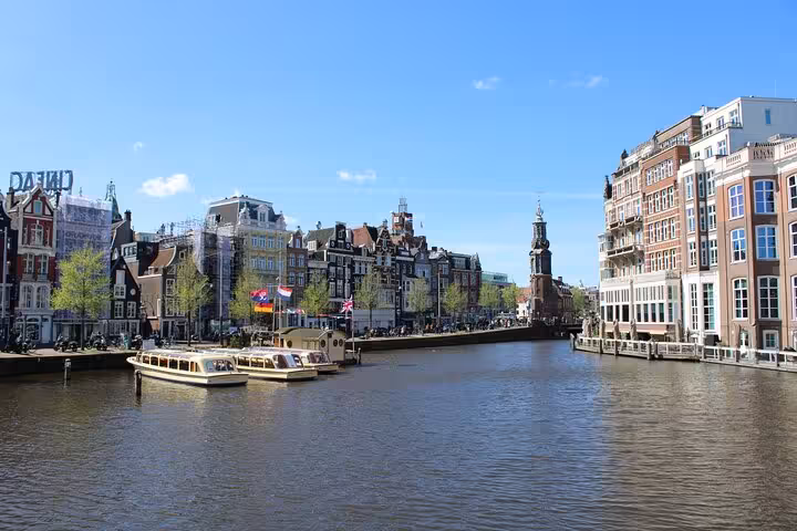 Wide Amsterdam canal view with boats and classic Dutch facades, ideal for a private city walk with a local
