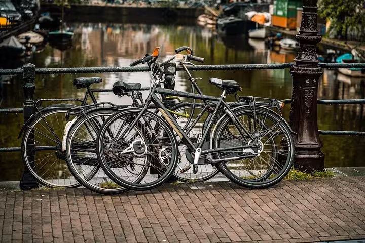 Bicycles parked by Amsterdam canal railing, perfect backdrop for Schiphol Airport to Utrecht private transfer