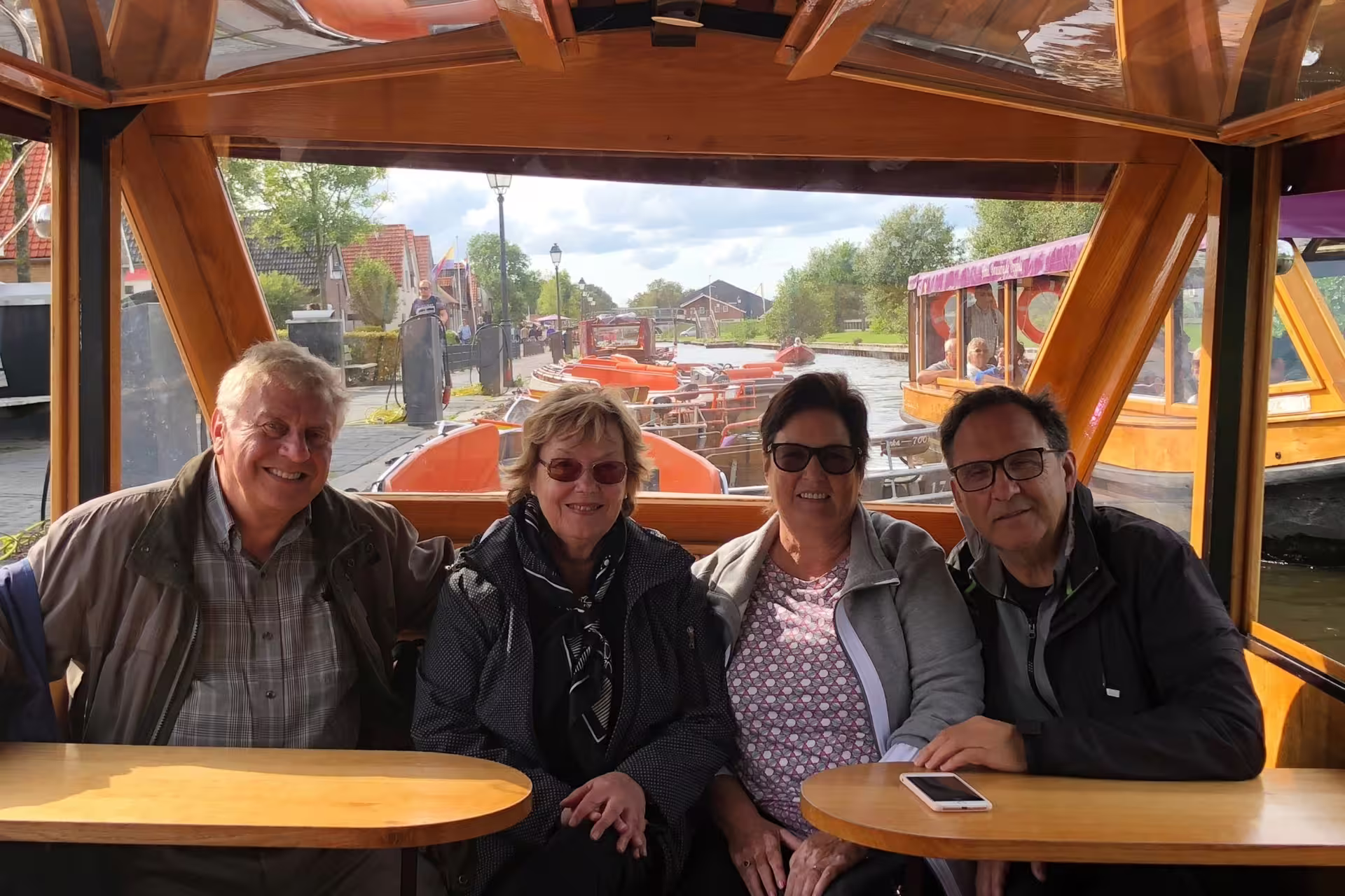 Guests relax on a Giethoorn canal boat during Amsterdam Keukenhof and Giethoorn day tour from Amsterdam