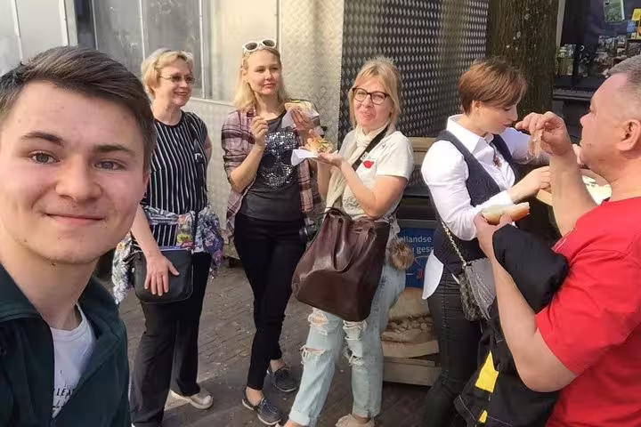 Tour group tasting Dutch snacks on an Amsterdam hidden gems walking tour with local guide and PDF map