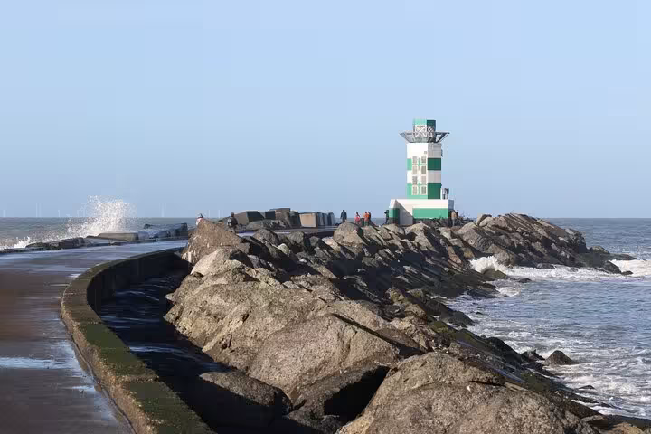 IJmuiden harbor breakwater with green-white beacon and waves, Amsterdam to IJmuiden private transfer route