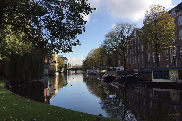 Scenic view of Amsterdam canal lined with historic buildings and trees, ideal for Jewish Quarter private tour experience.