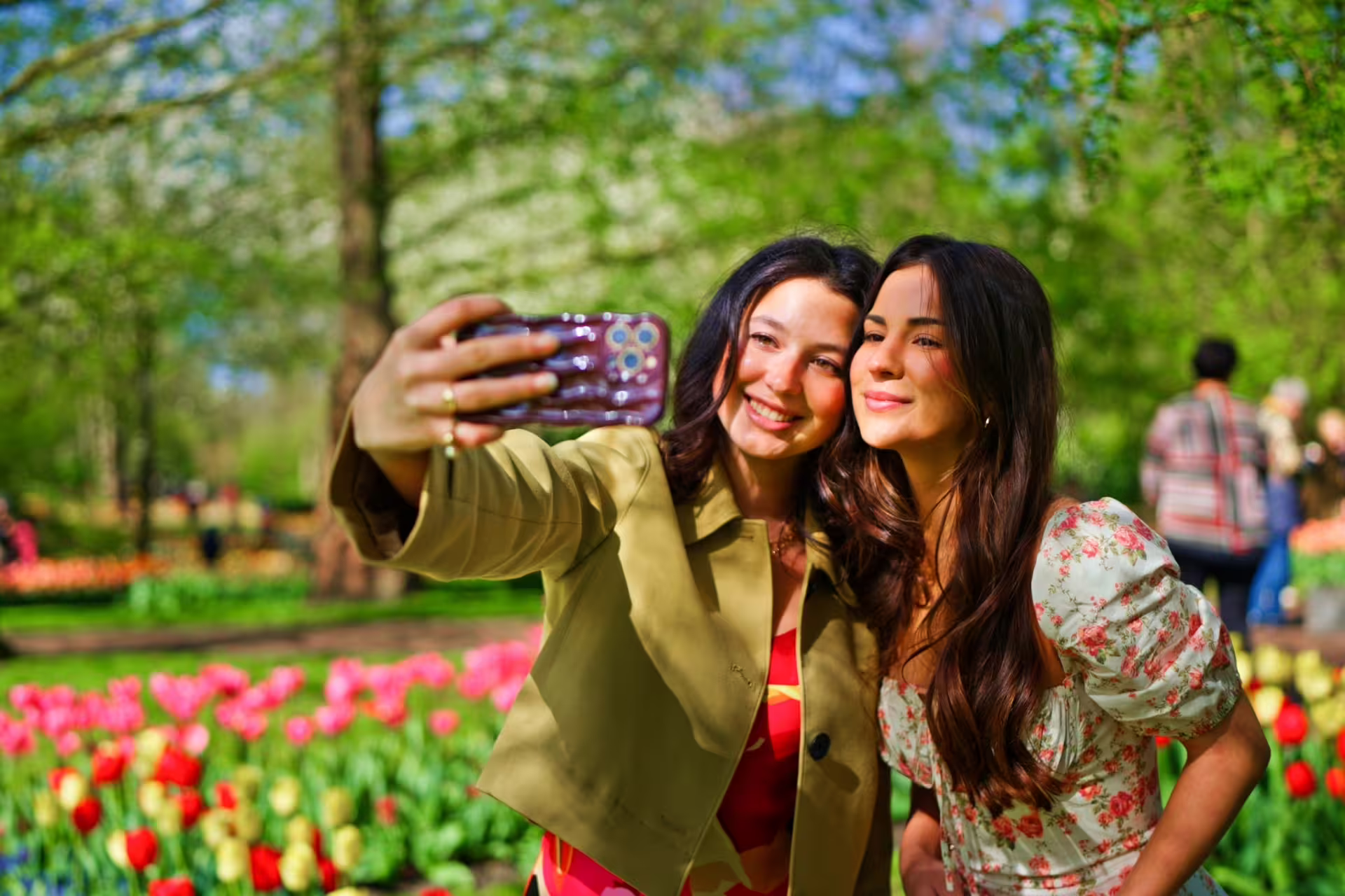 Friends taking a selfie in Keukenhof tulip gardens, a highlight of the Amsterdam spring day tour