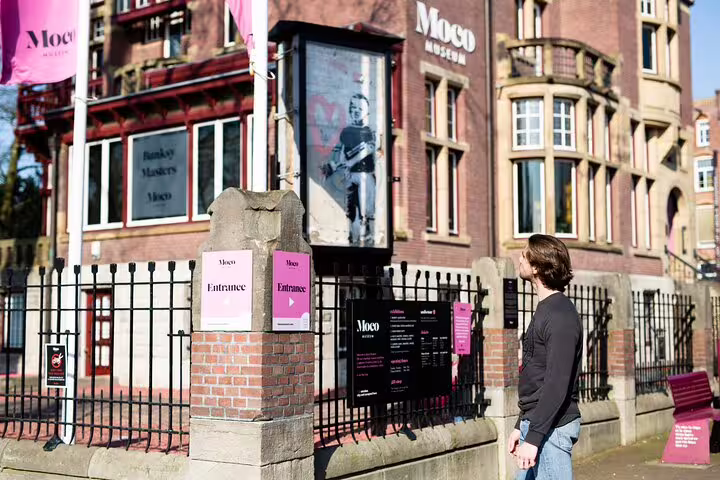 Visitor at the entrance of the Moco Museum in Amsterdam, showcasing modern art exhibits and cultural experiences.