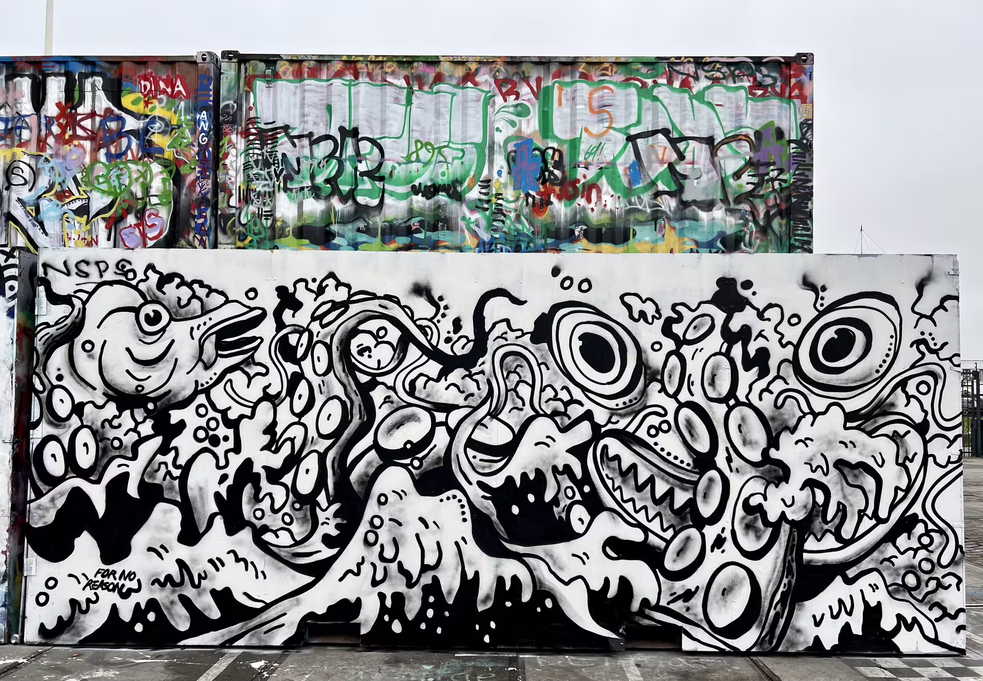 Vibrant graffiti art featuring abstract creatures and bold colors at Amsterdam's NDSM Wharf, highlighting urban creativity.