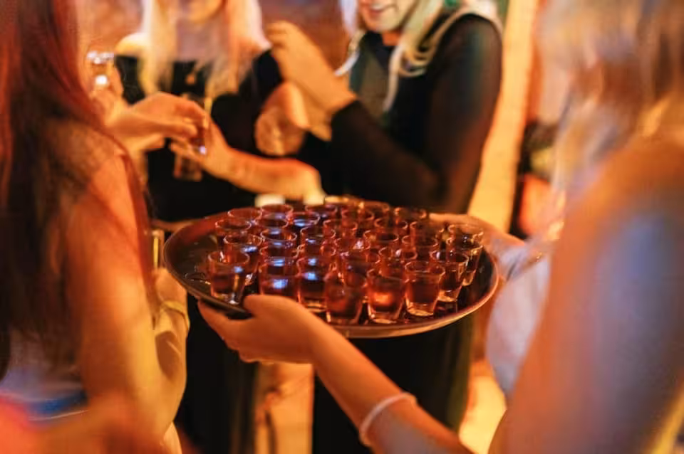 Tray of welcome shots served during Amsterdam New Year’s Eve pub crawl, party group in bar before VIP club entry