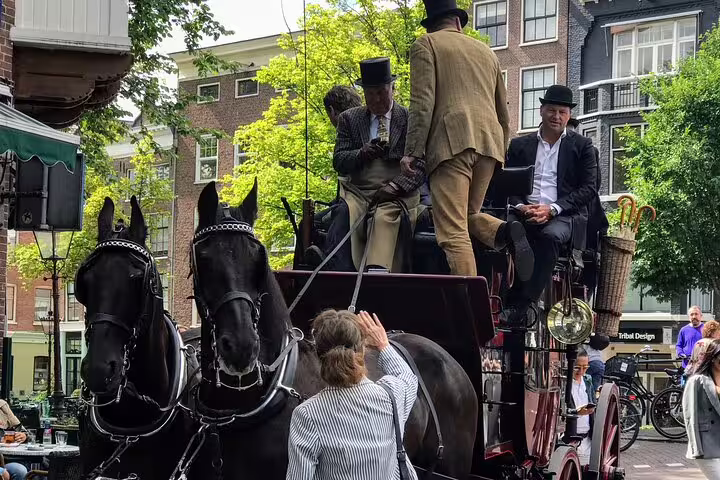 Horse-drawn carriage on an Amsterdam old city street, classic sights on a private guided tour