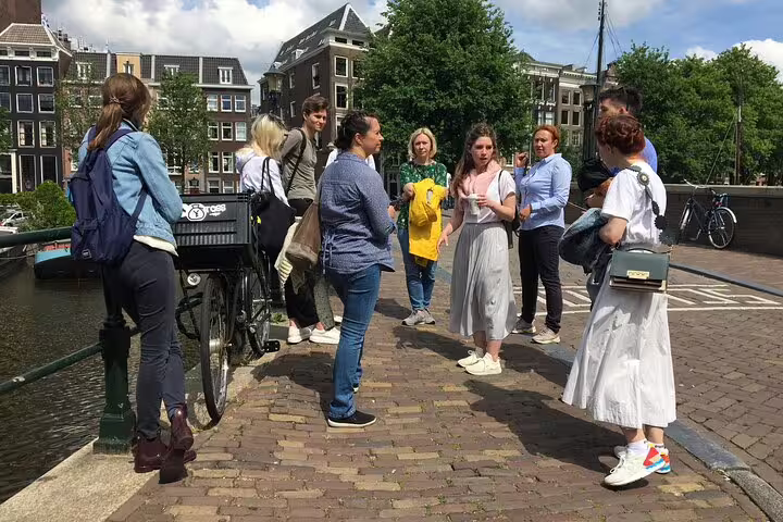 Small group with local guide on Amsterdam private walking tour by canal bridge and bikes