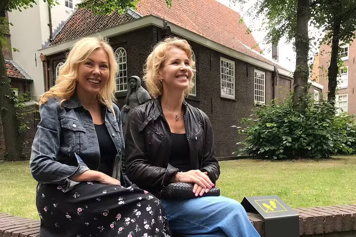 Smiling guests in a quiet Amsterdam courtyard, ideal for Amsterdam’s Unexpected Treasures private walk