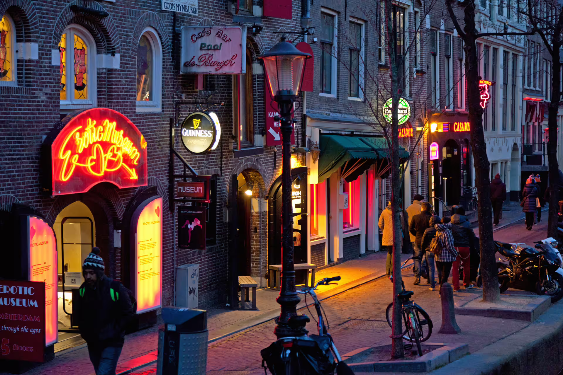 Neon-lit street in Amsterdam Red Light District at dusk, ideal for 1-day walking tour with audioguide