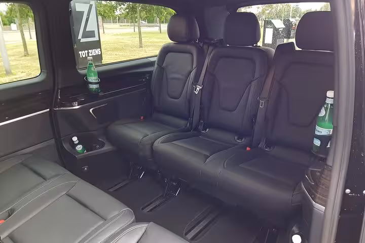 Spacious leather van interior with bottled water, comfortable Amsterdam to Schiphol Airport private transfer