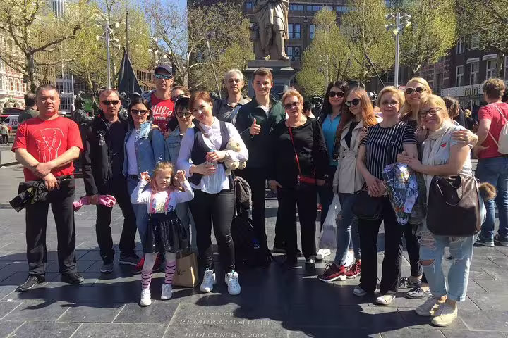 Small group at Dam Square on an Amsterdam sightseeing tour with hidden gems, tastings and PDF guide