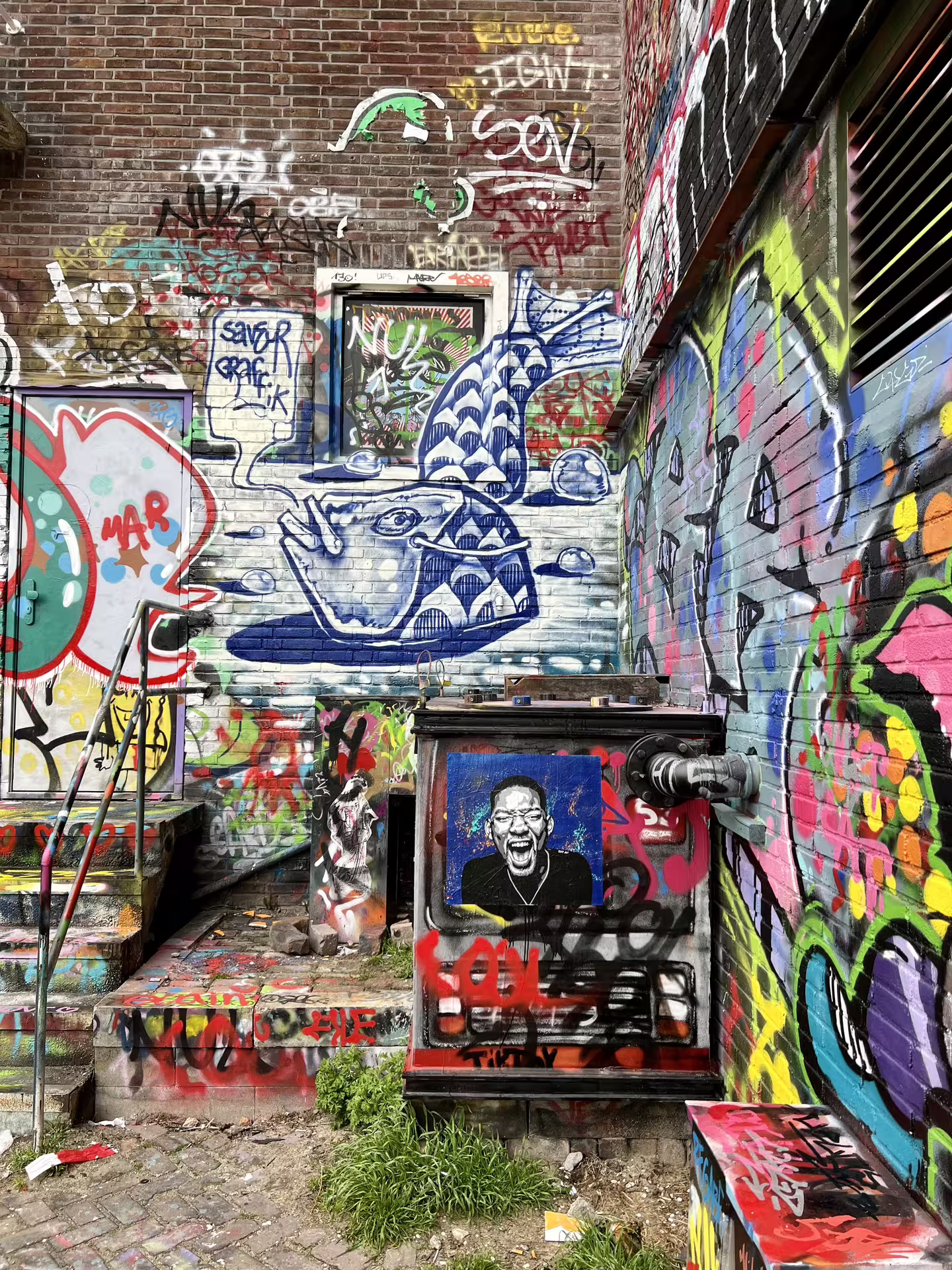 Vibrant street art covering walls at NDSM Wharf in Amsterdam, showcasing diverse graffiti styles for private art tour enthusiasts.