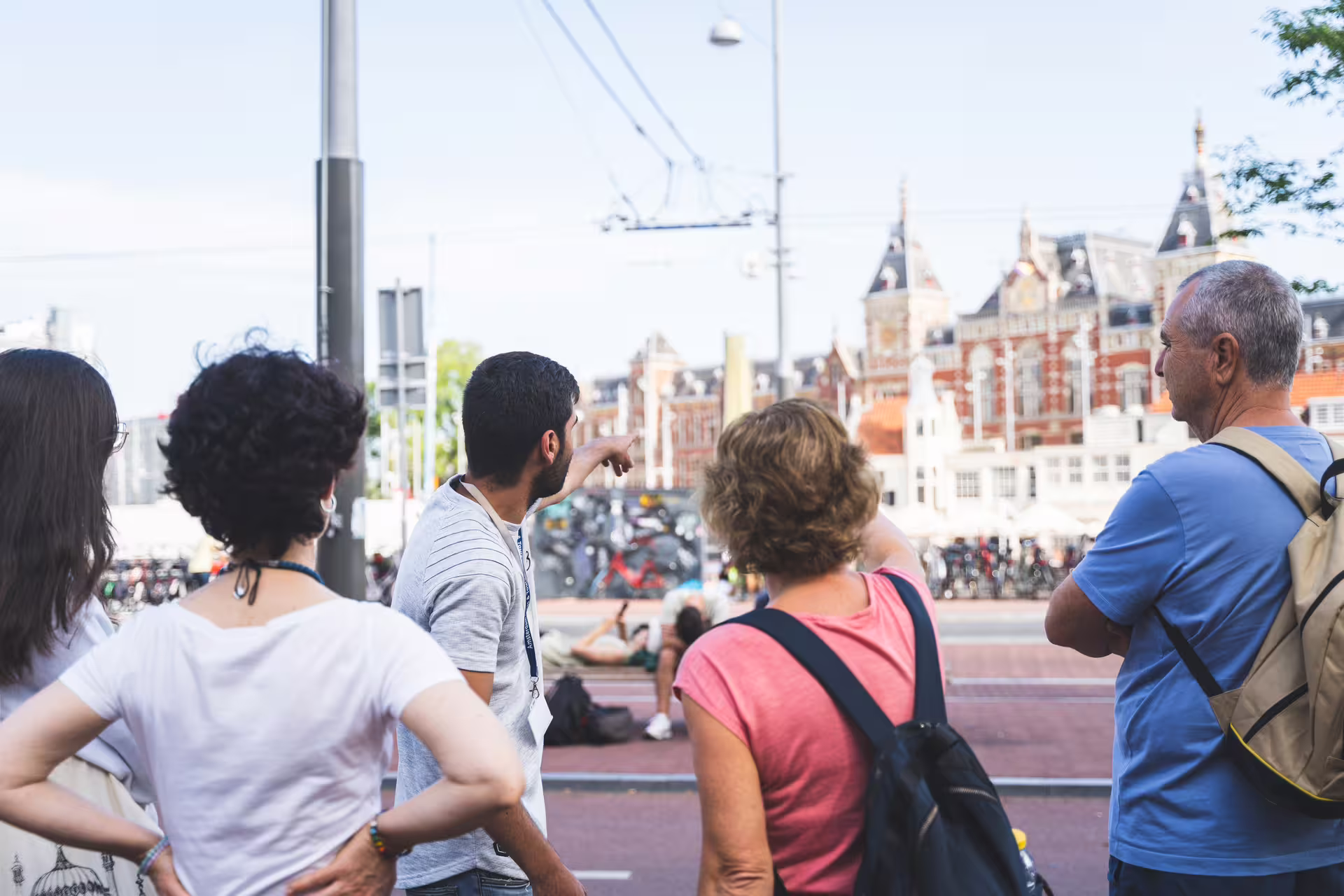 Tourists explore Amsterdam's historic architecture during a guided walking tour with a cheese tasting experience.