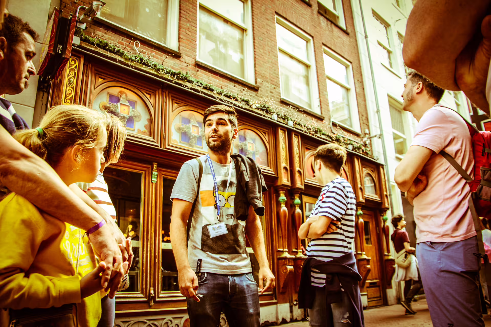 Tour guide leading a small group in front of a historic Amsterdam building during a vibrant walking tour.