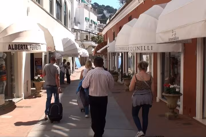 Visitors stroll through the charming shopping streets of Anacapri, lined with luxury boutiques and cafes.