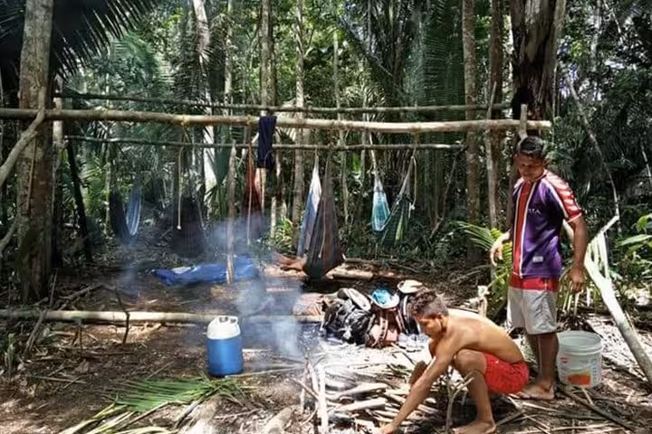 Amazonas jungle trek camp scene with hammock shelter and fire prep during 8-hour Anavilhanas tour