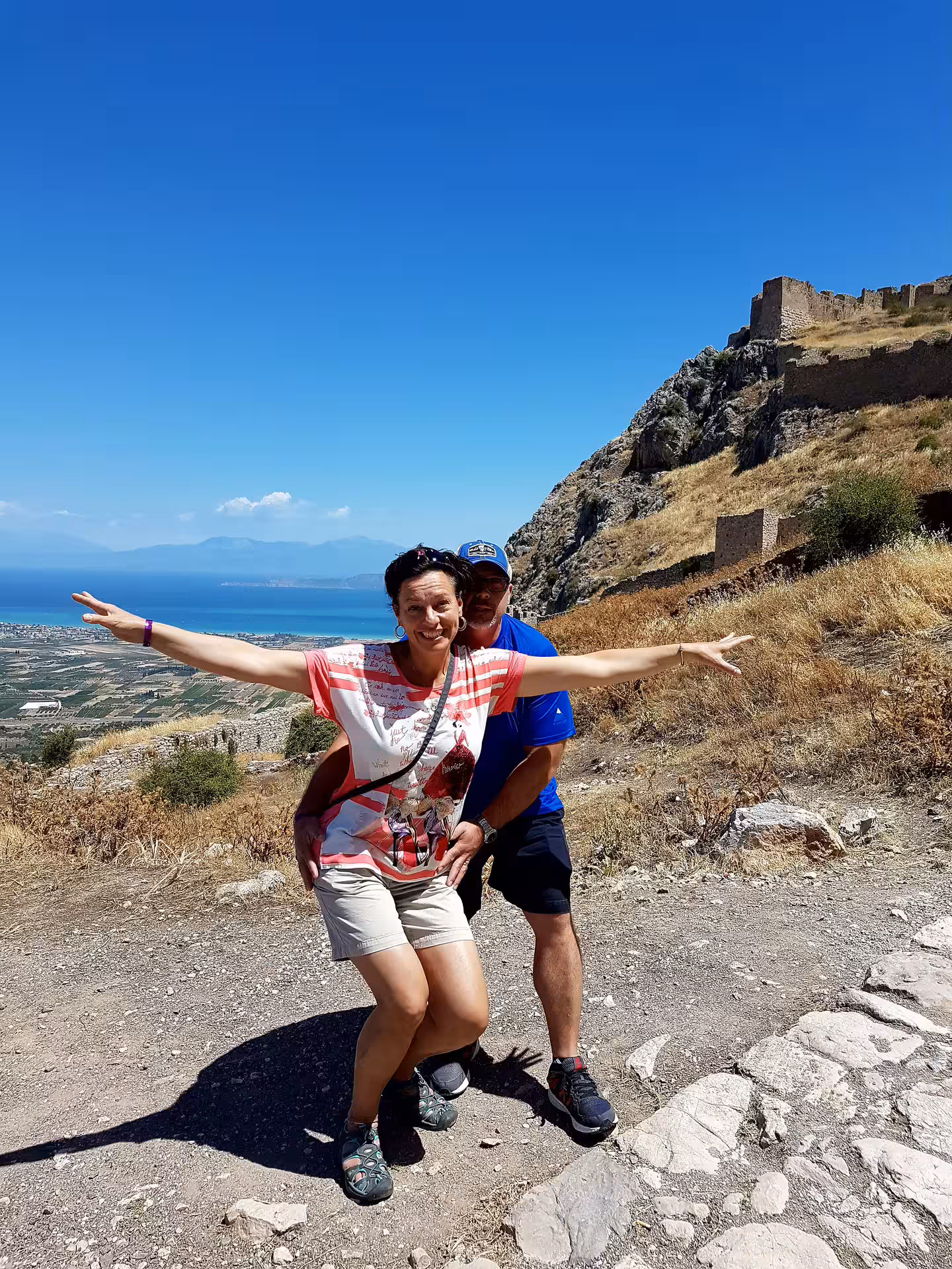 Travelers pose at Ancient Corinth Acrocorinth viewpoint on private tour from Athens, overlooking the Gulf of Corinth
