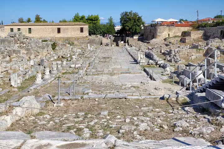 Ancient Corinth archaeological site walkway with stone ruins, featured stop on private half-day tour