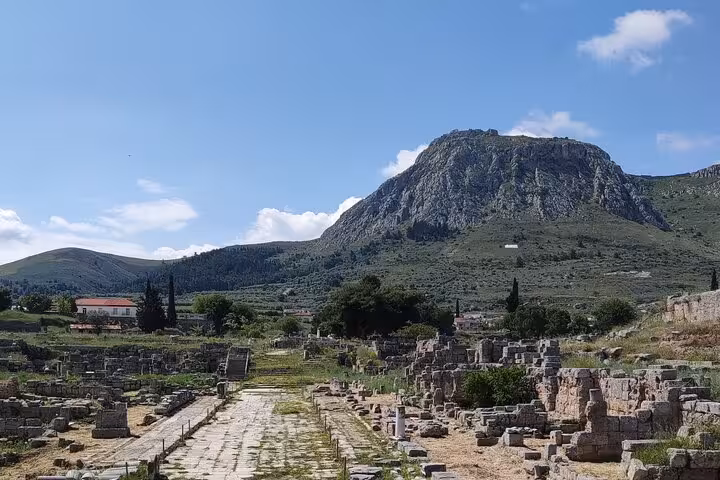 Ancient Corinth ruins and stone road beneath Acrocorinth, featured on Athens and Biblical Corinth private day tour
