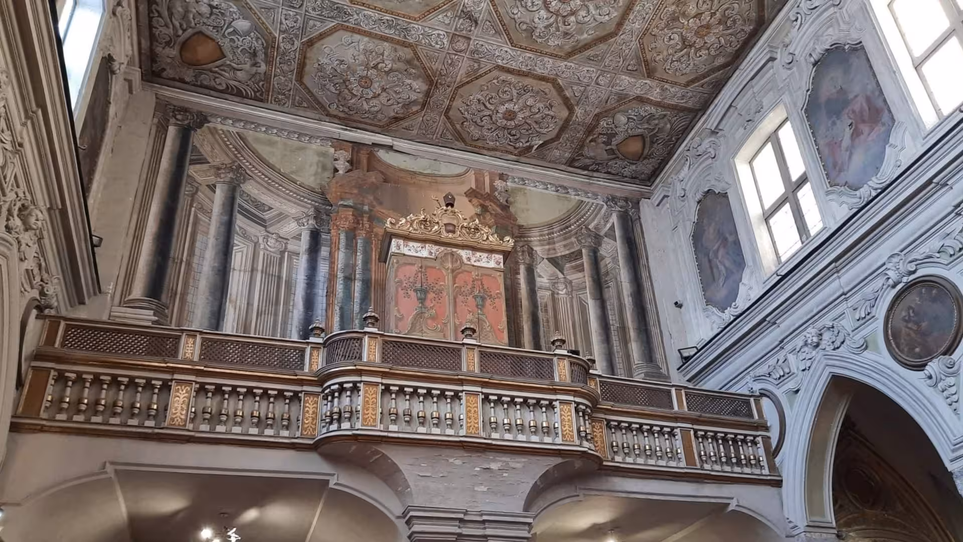 Ornate frescoed interior of an ancient building in Naples, showcasing Greek-Roman architectural elegance.