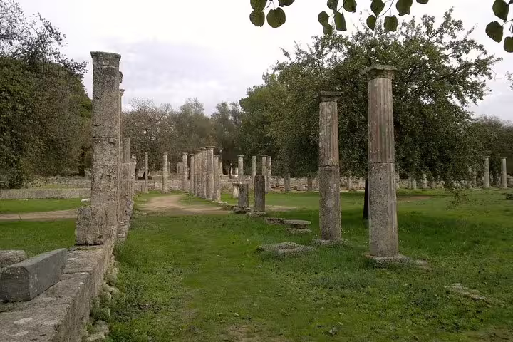 Stone columns and pathways at Ancient Olympia archaeological site, visited on a full-day private guided tour from Athens